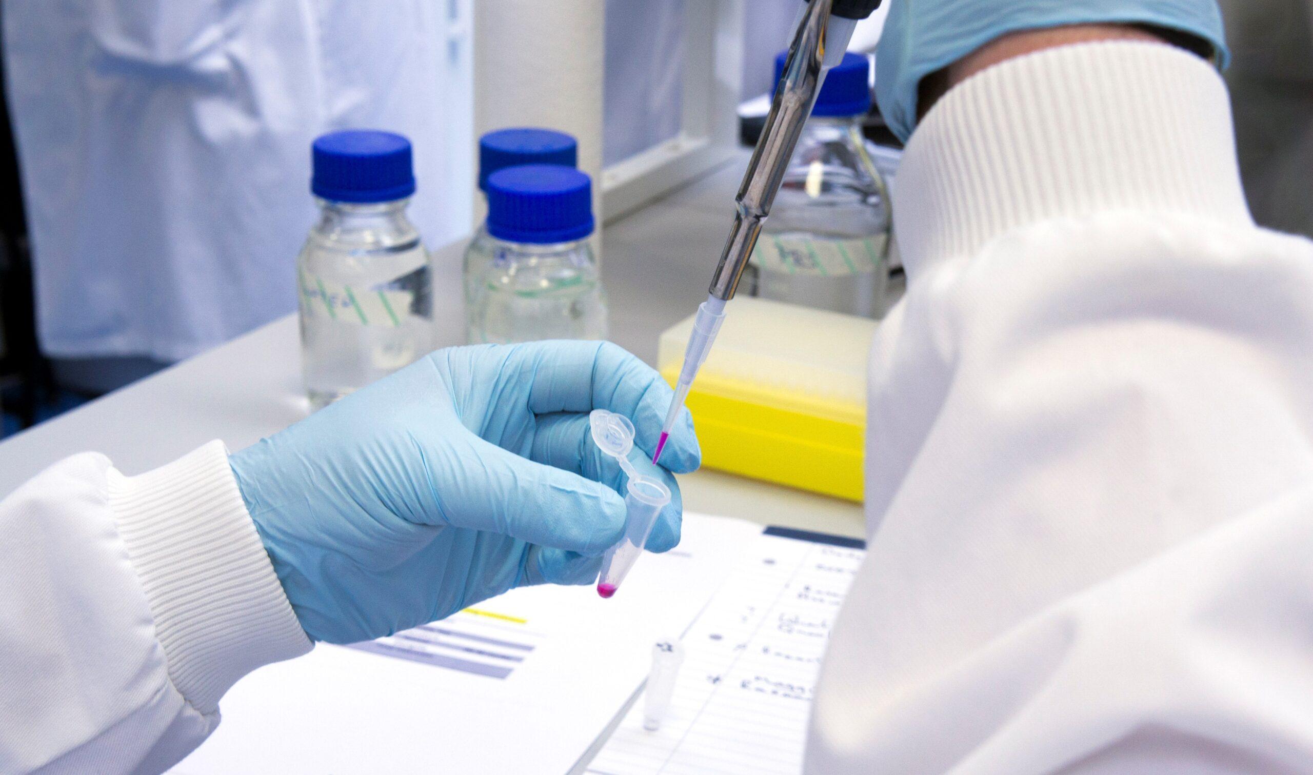 Scientist pippetting into an Eppendorf tube